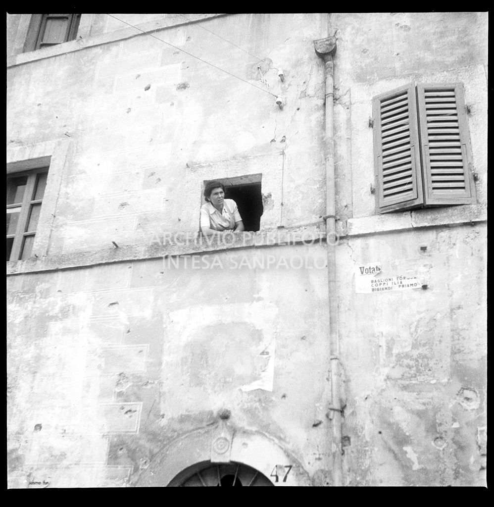 Una donna affacciata a una finestra ad Abbadia San Salvatore nei giorni successivi alla tentata insurrezione e all'uccisione di due ufficiali di polizia, dopo l'attentato a Palmiro Togliatti<br>42123