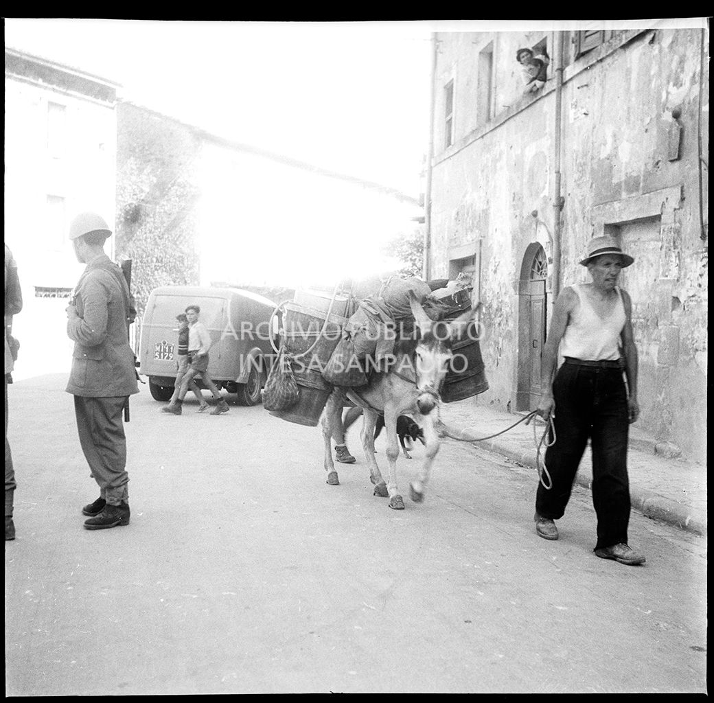 Un uomo con un carro tirato da un mulo passa a fianco a alcuni militari inviati a Abbadia San Salvatore nei giorni successivi alla tentata insurrezione e all'uccisione di due ufficiali di polizia, dopo l'attentato a Palmiro Togliatti<br>42125