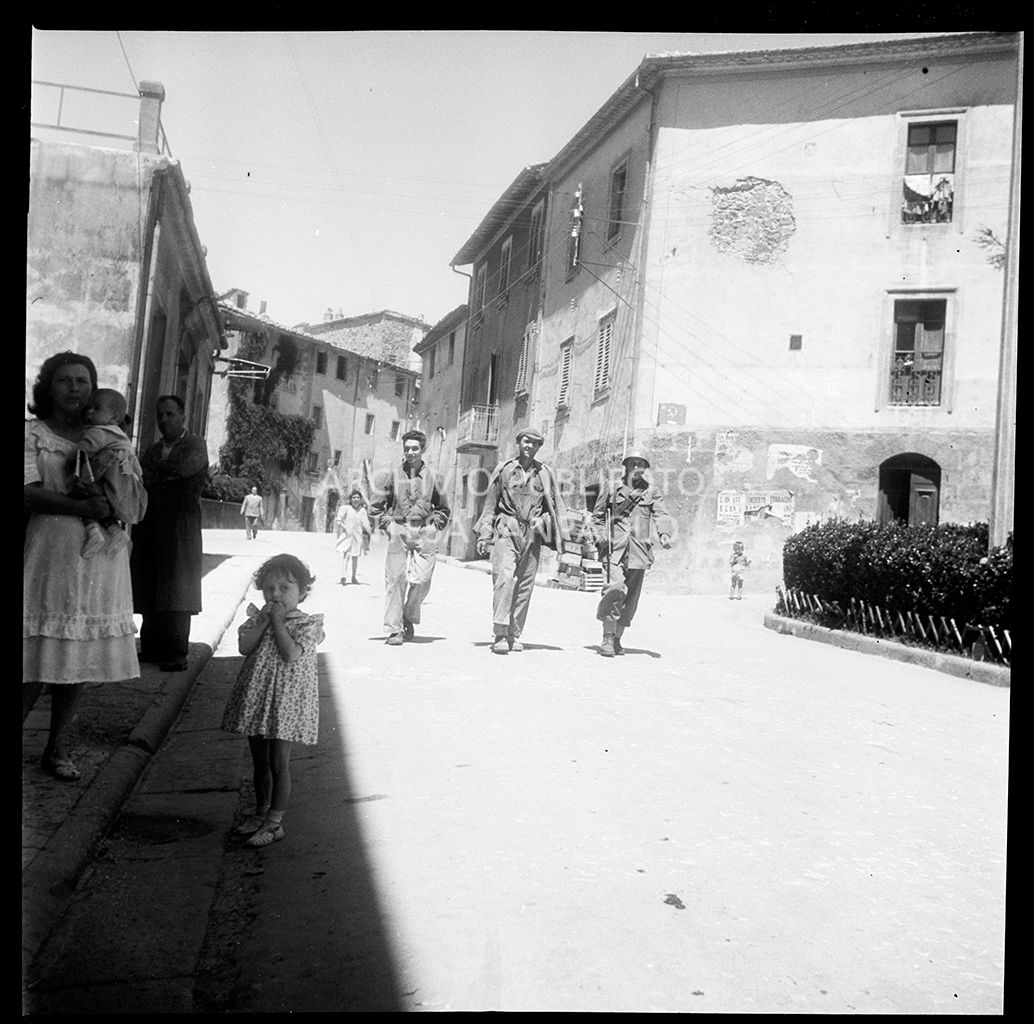 Due uomini e un militare per le strade di Abbadia San Salvatore nei giorni successivi alla tentata insurrezione e all'uccisione di due ufficiali di polizia, dopo l'attentato a Palmiro Togliatti<br>42129