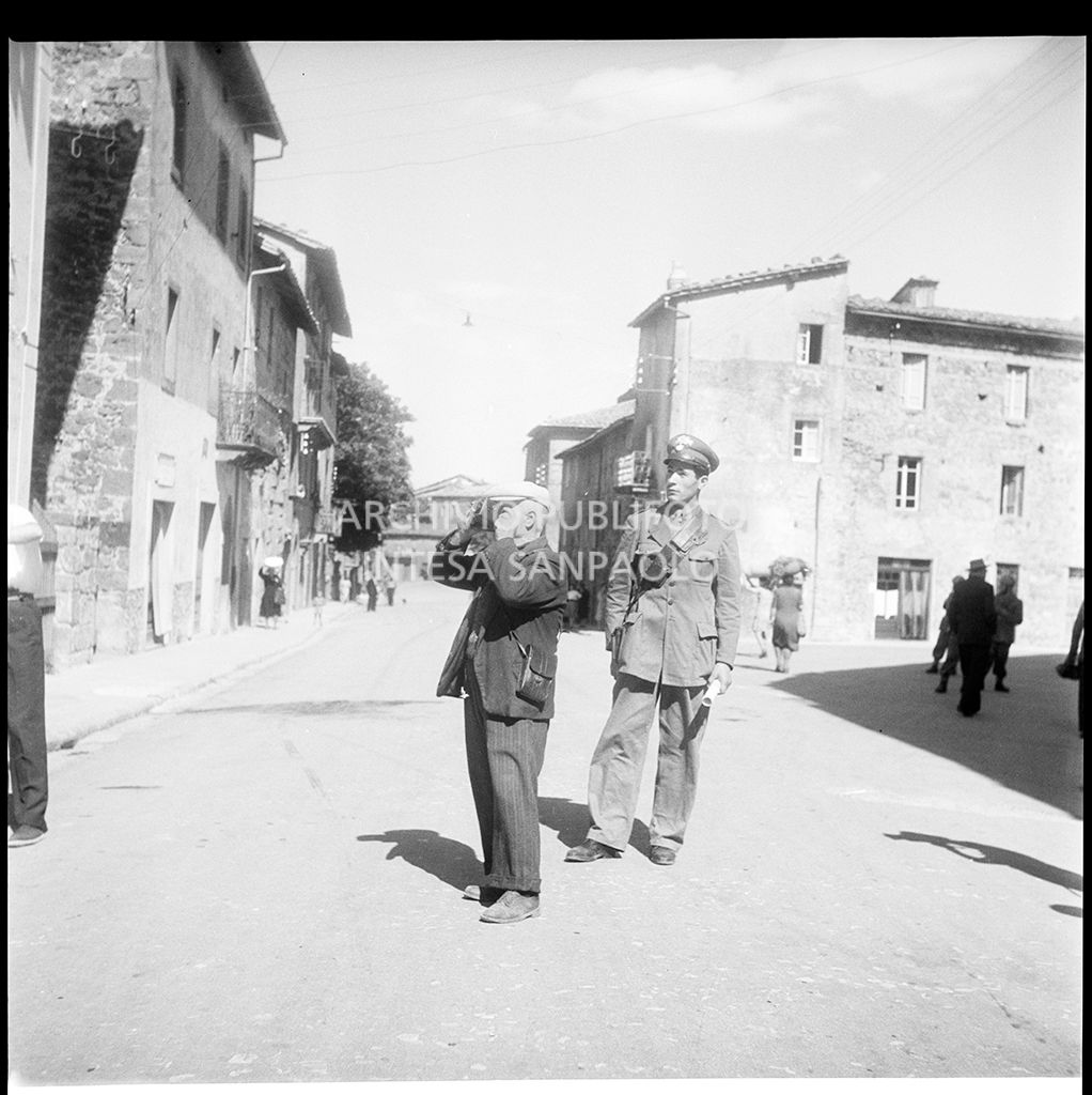 Un carabiniere osserva un fotografo al lavoro ad Abbadia San Salvatore nei giorni successivi alla tentata insurrezione e all'uccisione di due ufficiali di polizia, dopo l'attentato a Palmiro Togliatti<br>42136