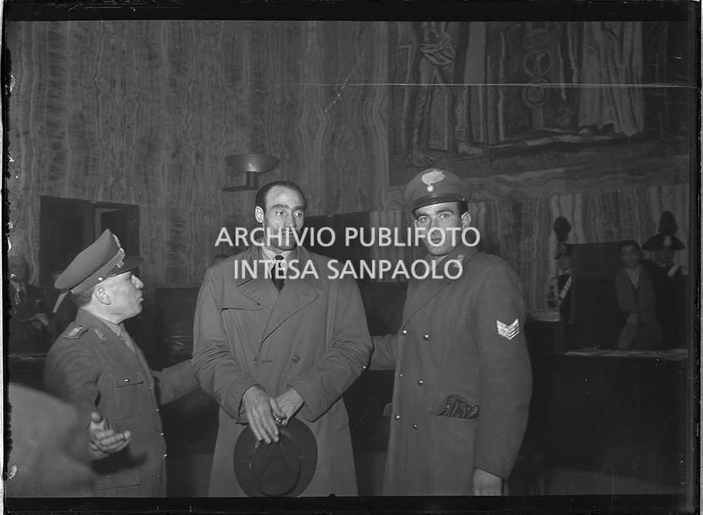 Giuseppe Ricciardi, marito e padre delle vittime Franca Pappalardo e i tre bambini, tra due carabinieri nell'aula del Tribunale di Milano dove è in corso il processo in Corte d'Assise a Caterina Fort<br>64325