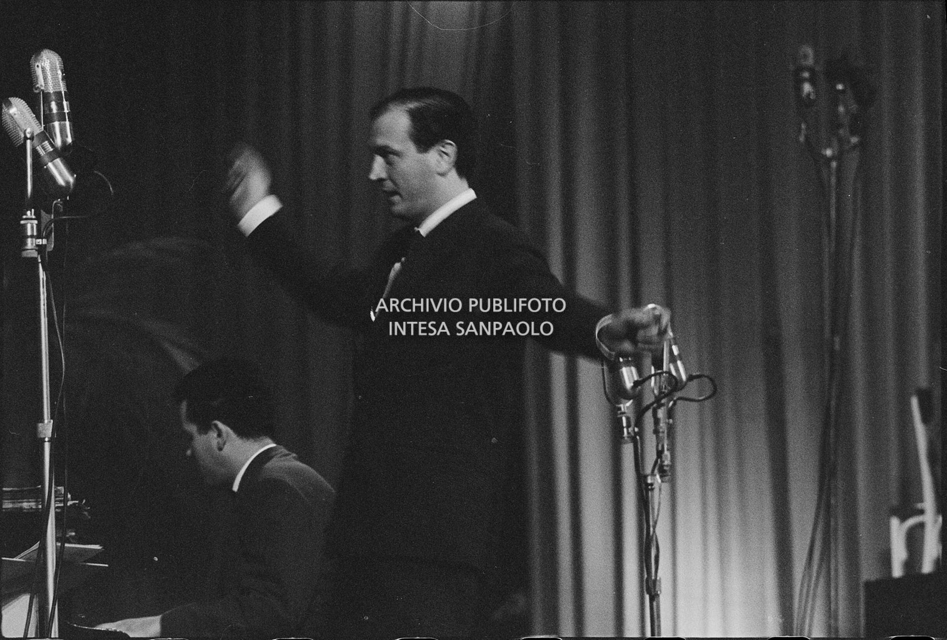 Il maestro Gianni Ferrio dirige l'orchestra al IX Festival della canzone italiana di Sanremo