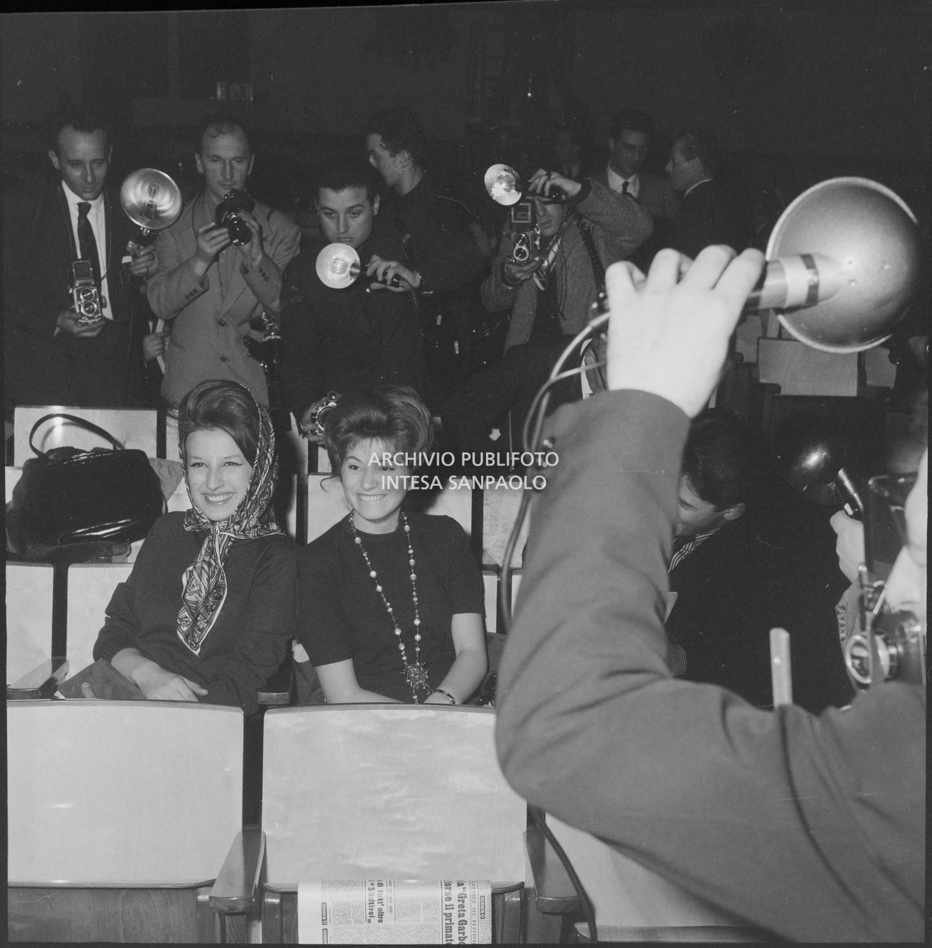 Mina e Miranda Martino sedute in platea durante le prove dell'XI Festival di Sanremo riprese da molti fotografi