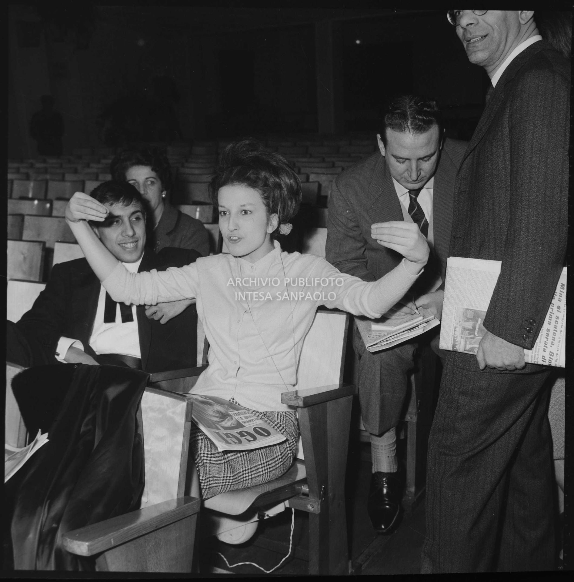 Mina gesticola seduta in platea durante le prove dell'XI Festival di Sanremo; al suo fianco Adriano Celentano