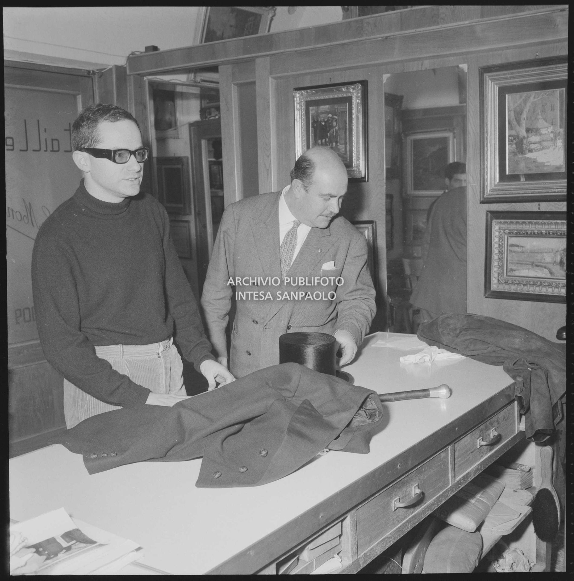 Gino Paoli sceglie frac e cilindro da indossare nei giorni dell'XI Festival di Sanremo in un atelier con l'insegna "tailleur"