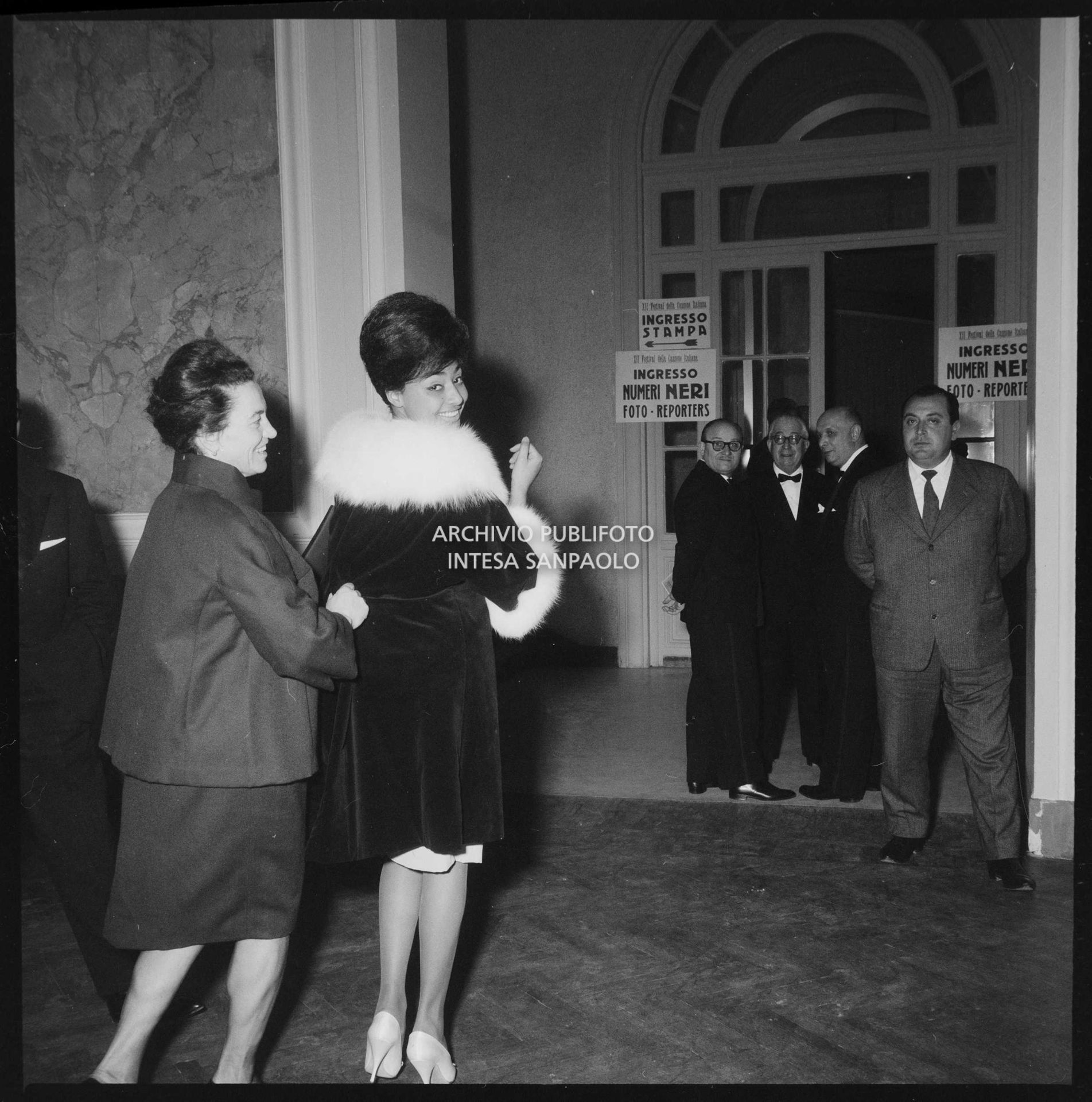 Tanya di spalle sorride al fotografo avviandosi a entrare al Casinò di Sanremo nei giorni del Festival