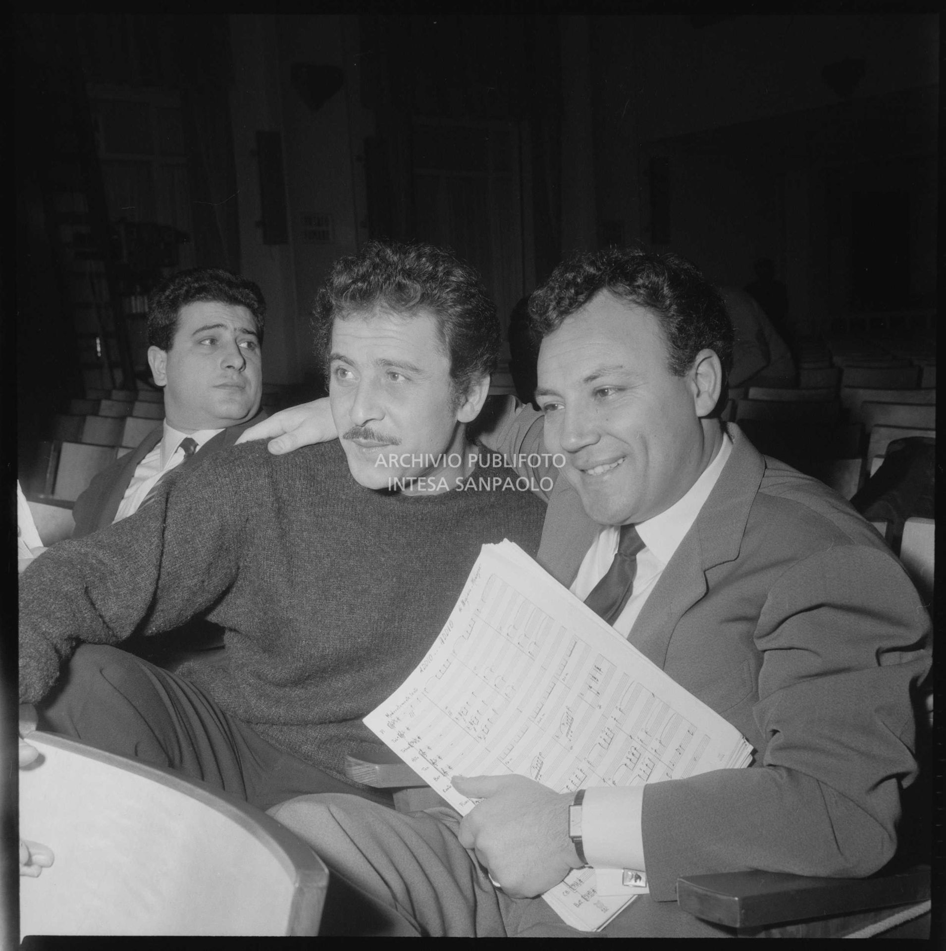 Da sinistra Domenico Modugno e Claudio Villa, con in mano uno spartito musicale, seduti in platea durante le prove del Festival di Sanremo