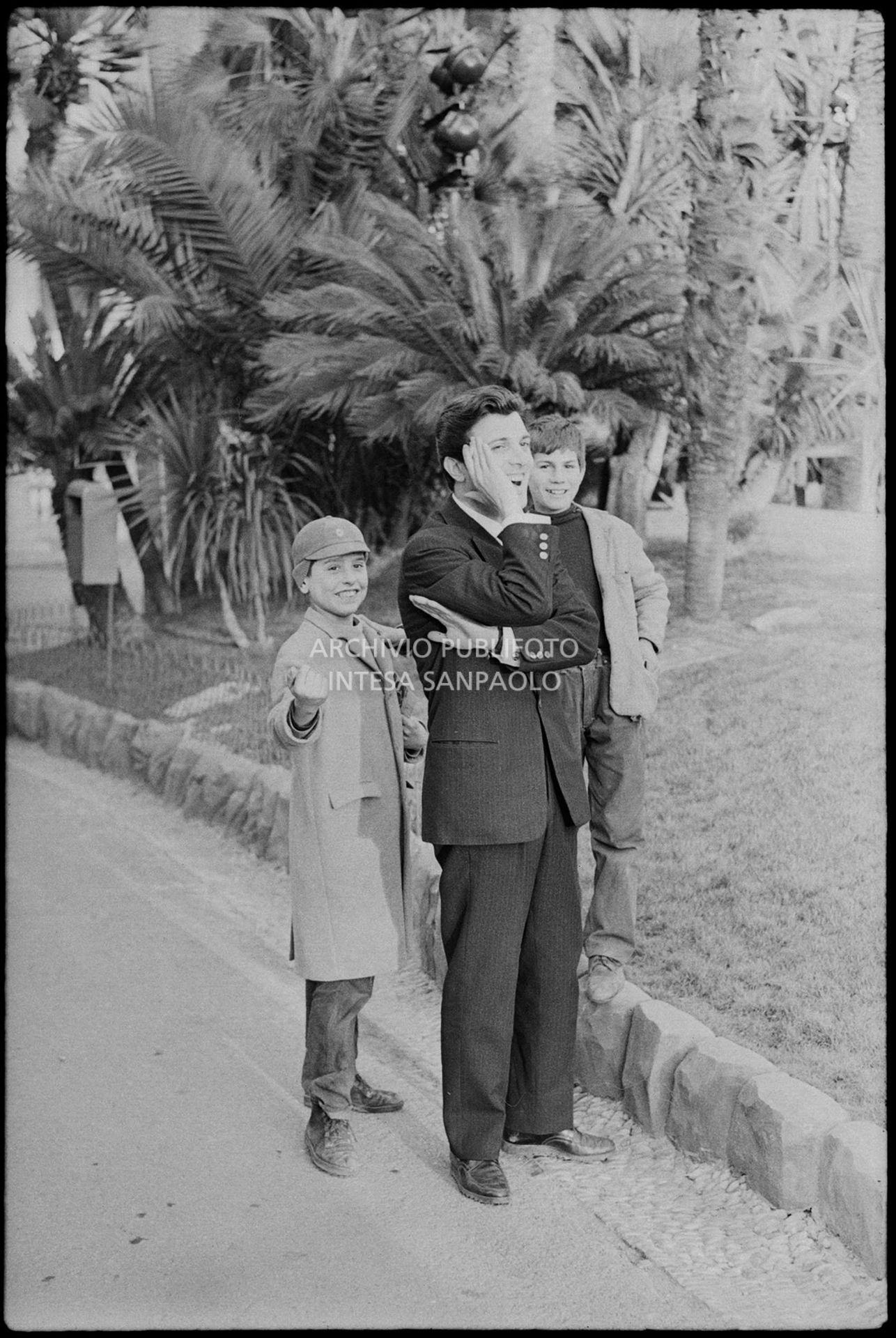 Gianni La Commare gioca allo schiaffo del soldato con dei ragazzini nei giorni del XIII Festival della canzone italiana di Sanremo