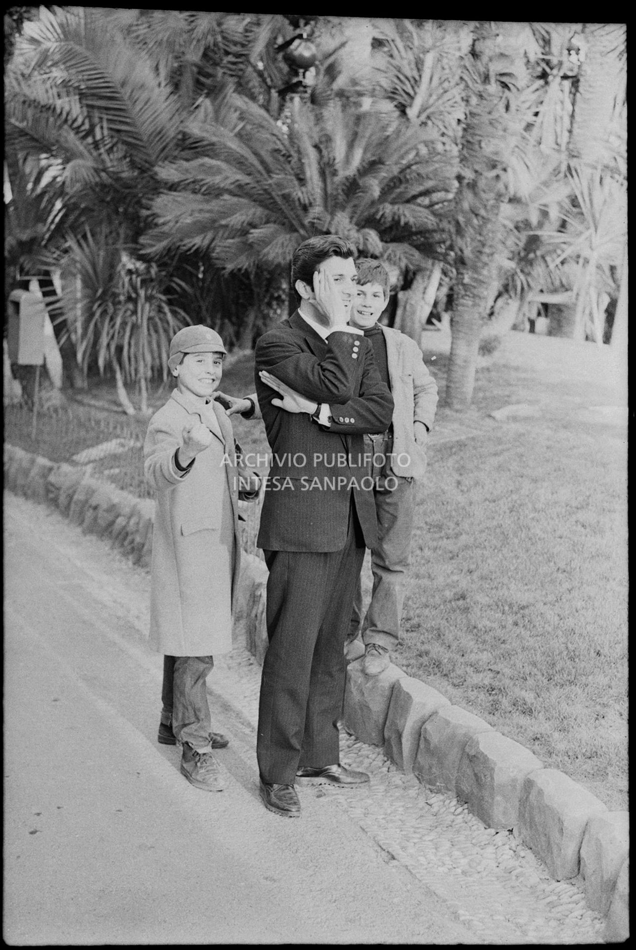 Gianni La Commare gioca allo schiaffo del soldato con dei ragazzini nei giorni del XIII Festival della canzone italiana di Sanremo