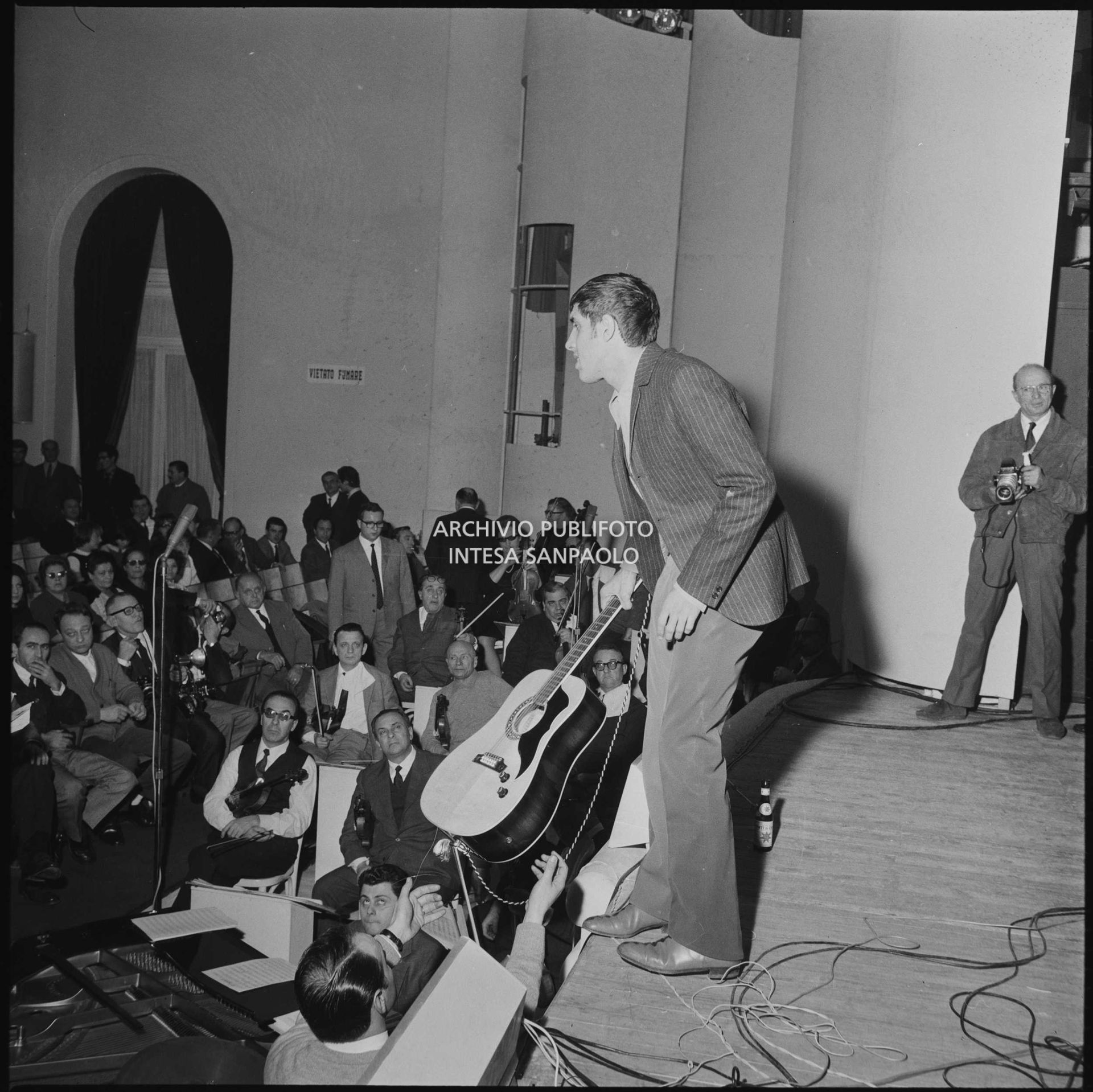 Adriano Celentano con la chitarra sul palco del salone delle feste del Casinò di Sanremo durante le prove