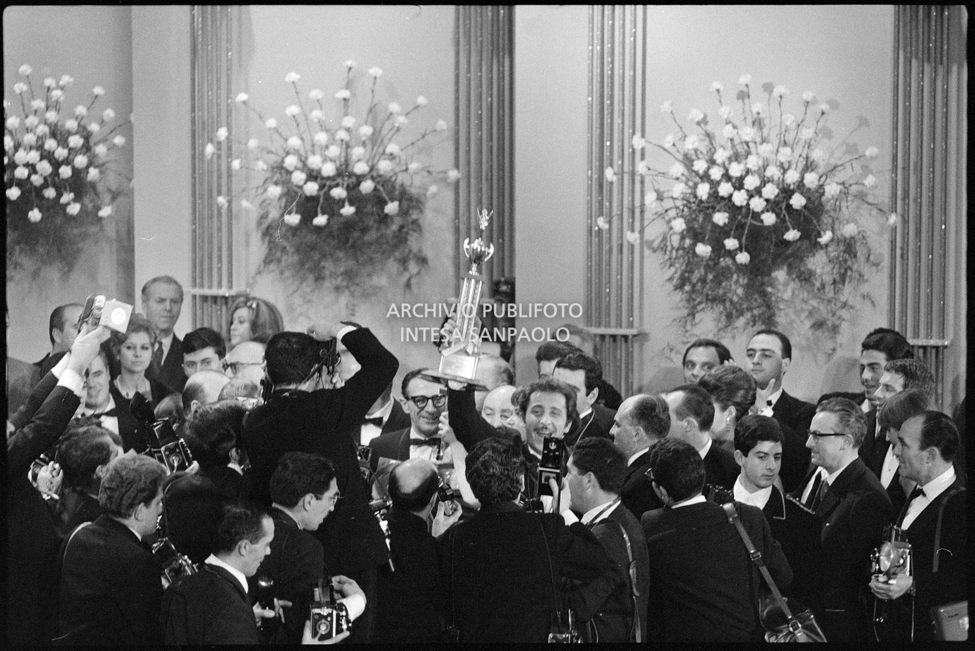 I fotografi circondano i vincitori del XVI Festival della canzone italiana di Sanremo, Gigliola Cinquetti e Domenico Modugno
