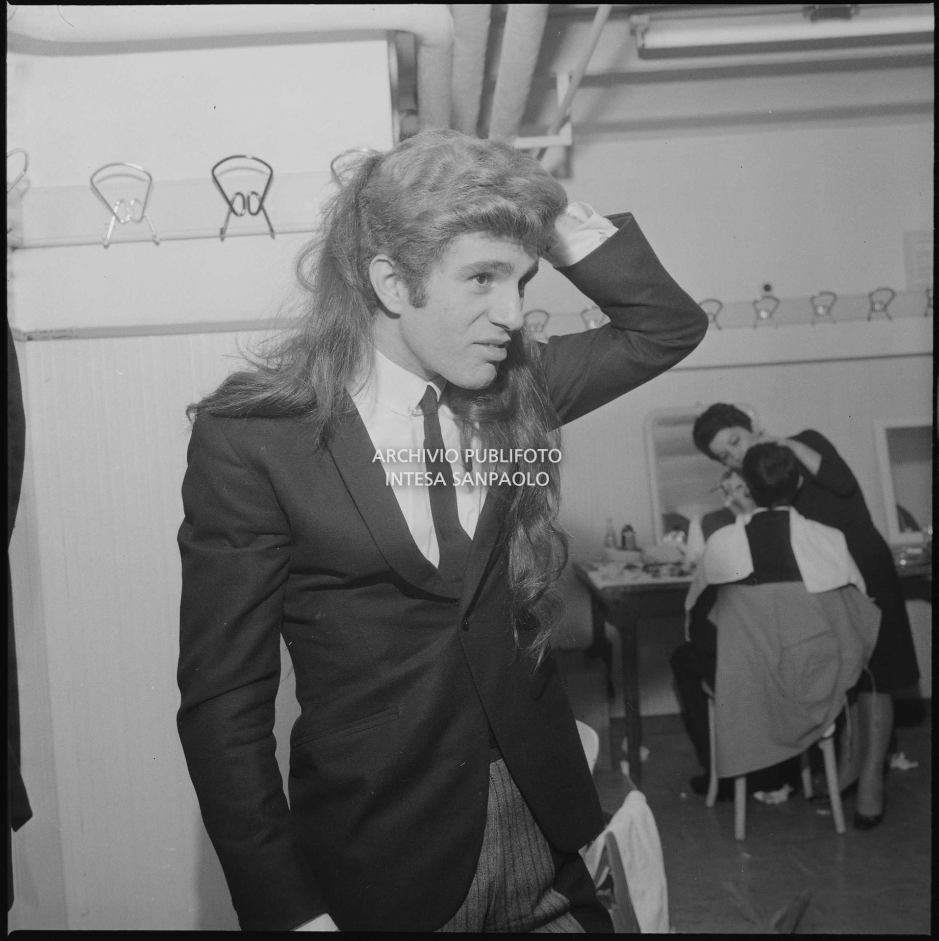 Uno dei membri del gruppo I Ribelli, in sala trucco al XVI Festival di Sanremo, indossa una parrucca