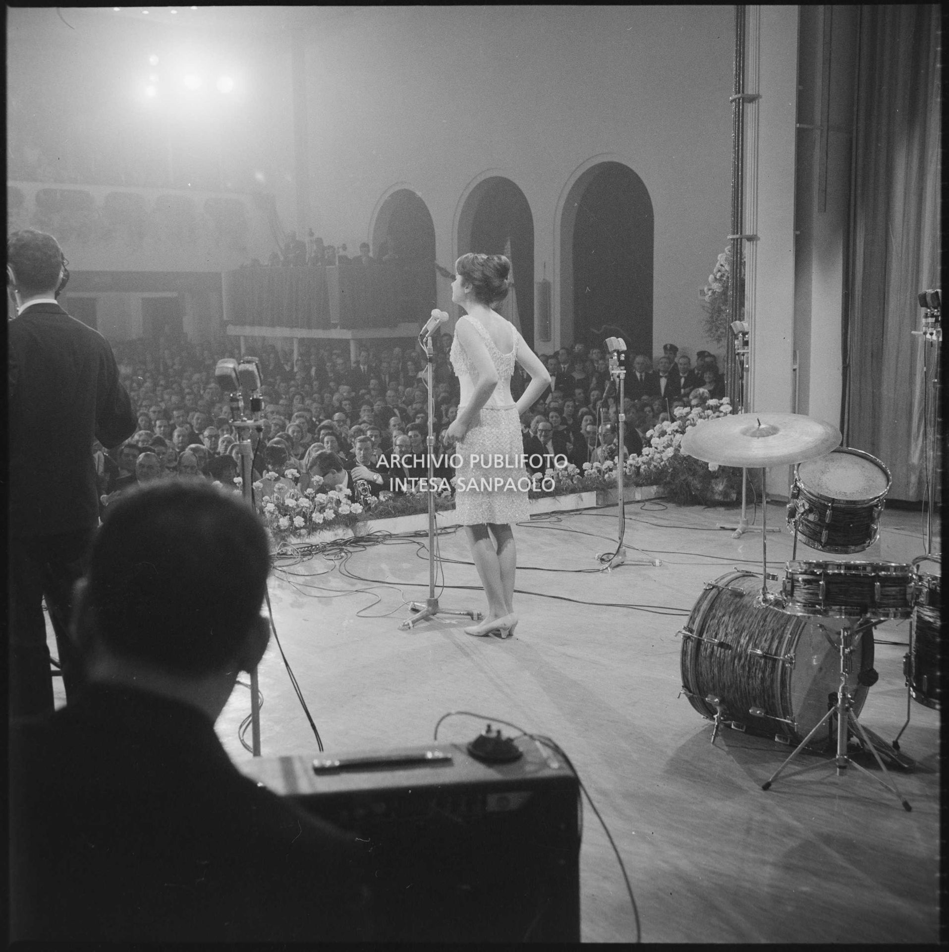 Gigliola Cinquetti ripresa di spalle mentre canta sul palco del XVI Festival di Sanremo