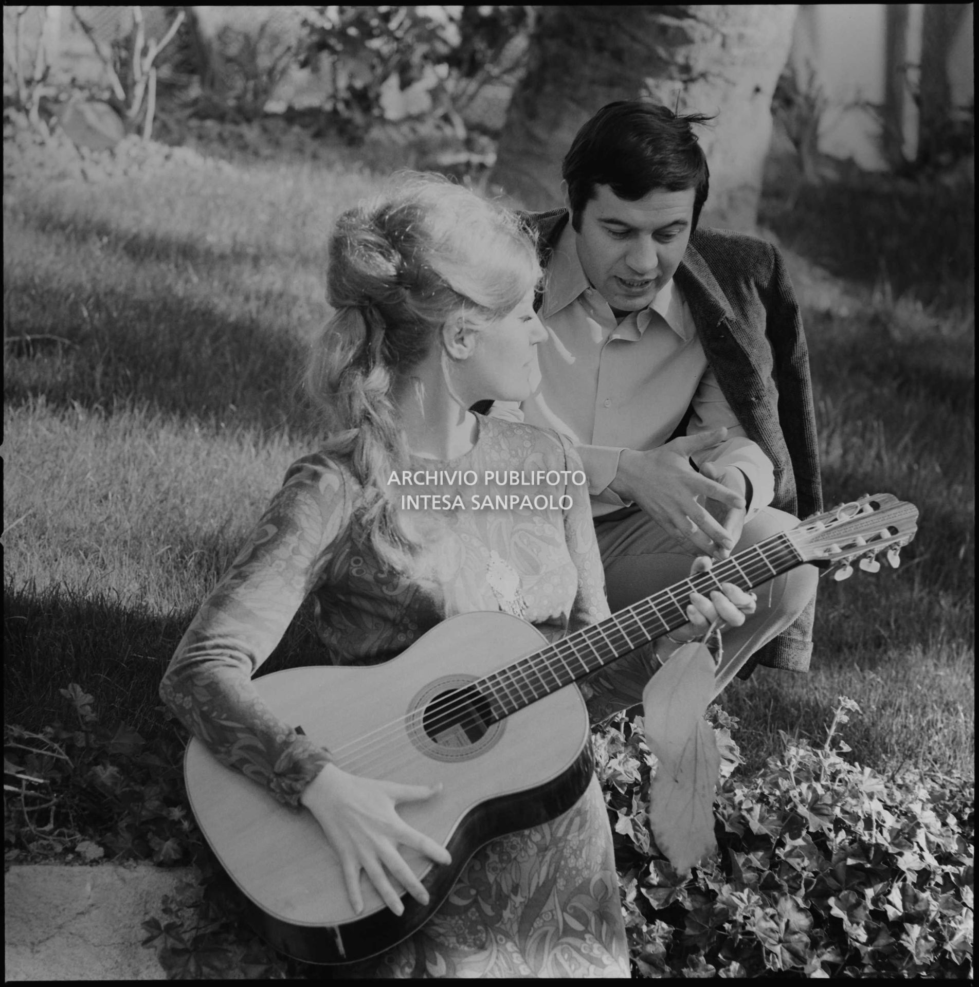 Anna German, con la chitarra, e Fred Bongusto seduti sull'erba