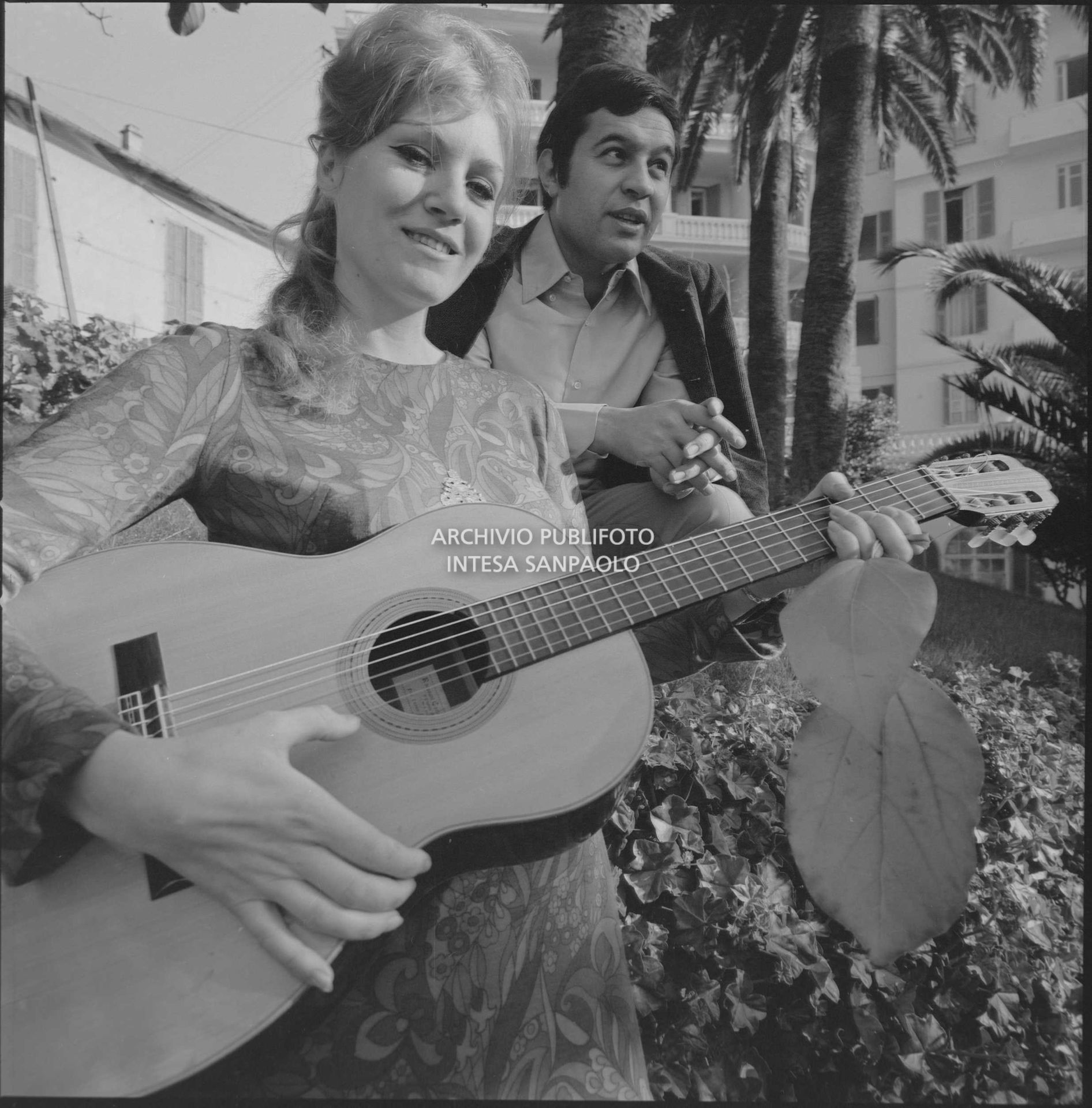 Anna German, con la chitarra, e Fred Bongusto, seduti su un muretto a Sanremo nei giorni del Festival