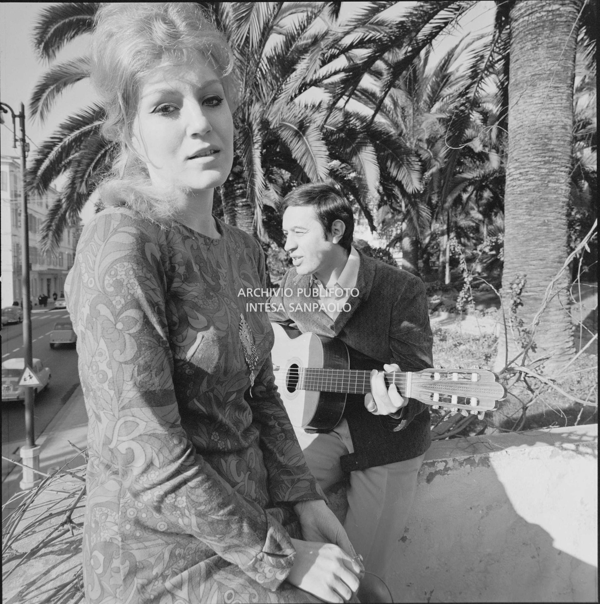 Anna German e Fred Bongusto, con la chitarra, seduti su un muretto a Sanremo nei giorni del Festival