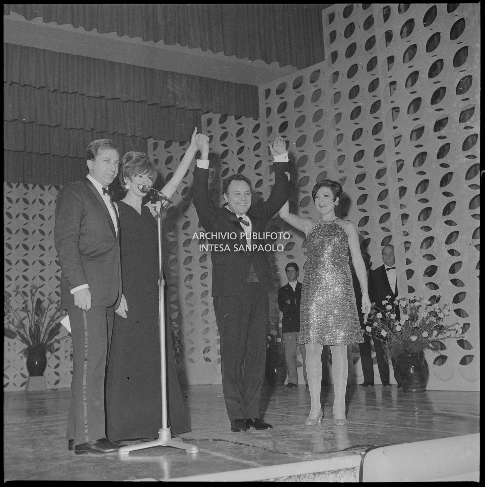 I presentatori Renata Maura e Mike Bongiorno sul palco del Salone delle feste del Casinò municipale con i vincitori del XVII Festival  di Sanremo, Iva Zanicchi e Claudio Villa