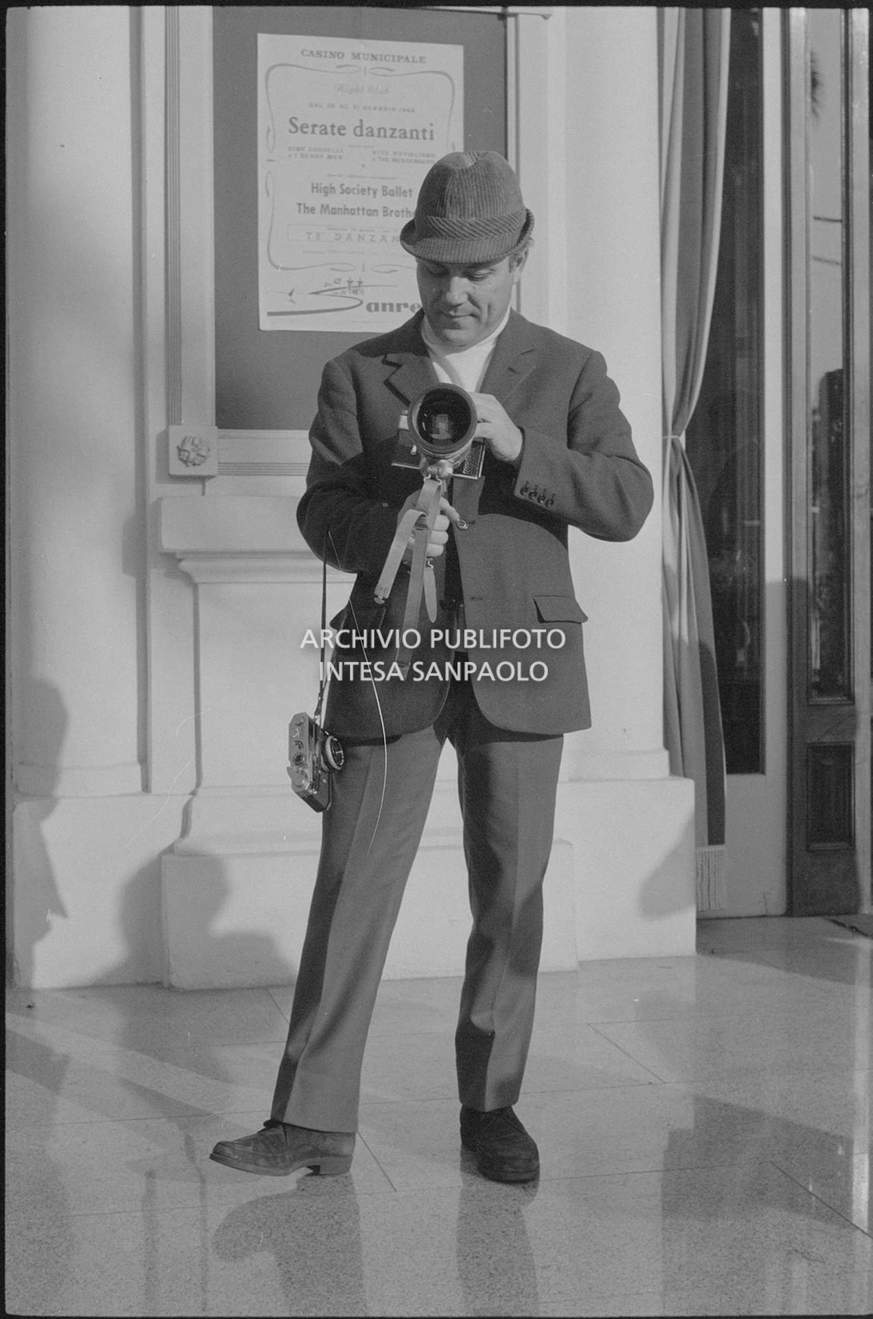 Claudio Villa, in veste di fotoreporter, all'esterno del Casinò nei giorni del XVIII Festival della canzone italiana di Sanremo