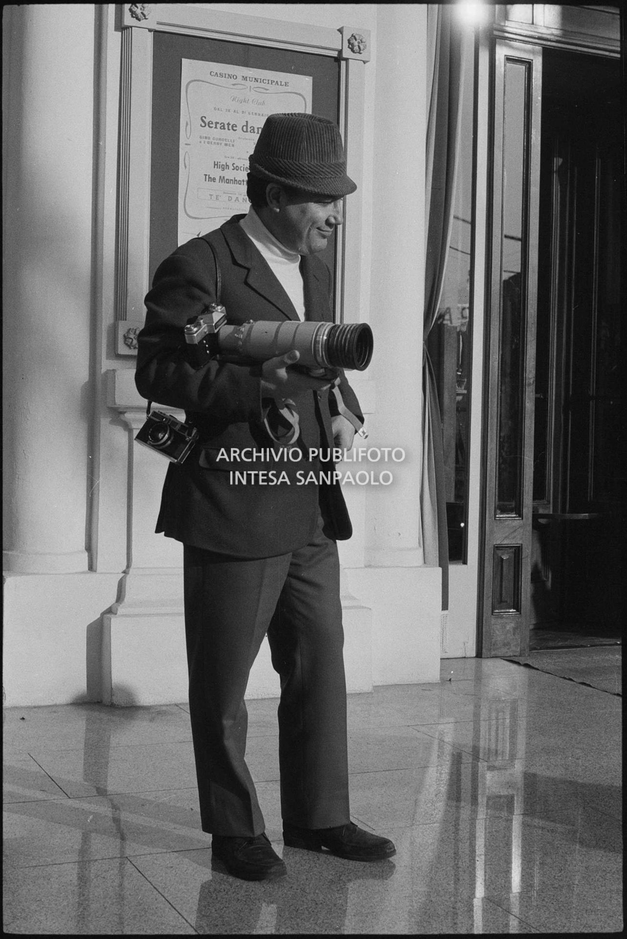 Claudio Villa, in veste di fotoreporter, all'esterno del Casinò nei giorni del XVIII Festival della canzone italiana di Sanremo
