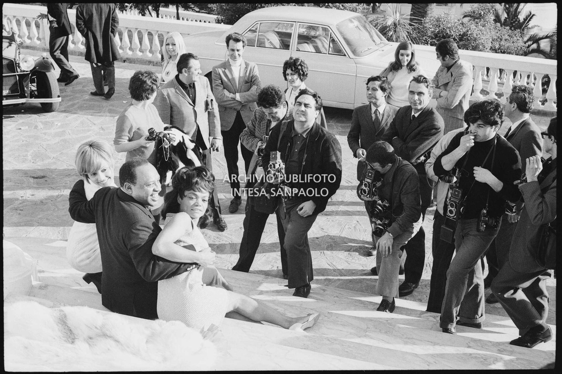 Lara Saint Paul, Lionel Hampton e Eartha Kitt attorniati da fotografi all'esterno del Casinò nei giorni del XVIII Festival della canzone italiana di Sanremo