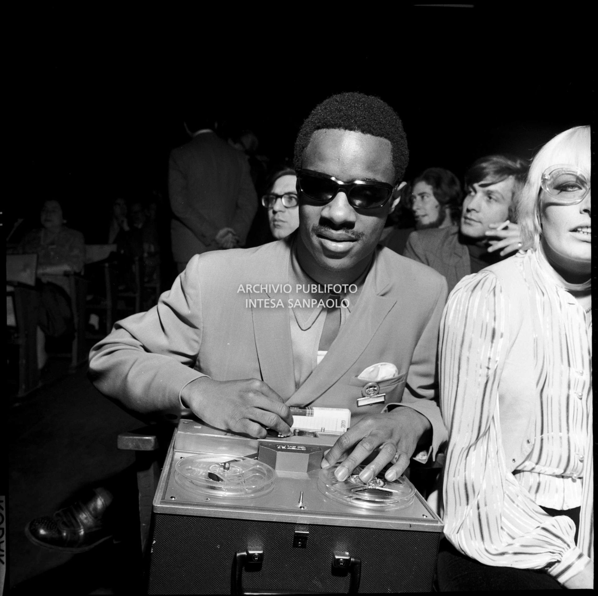 Stevie Wonder, con un registratore a nastro, seduto in platea in occasione delle le prove del XIX Festival di Sanremo