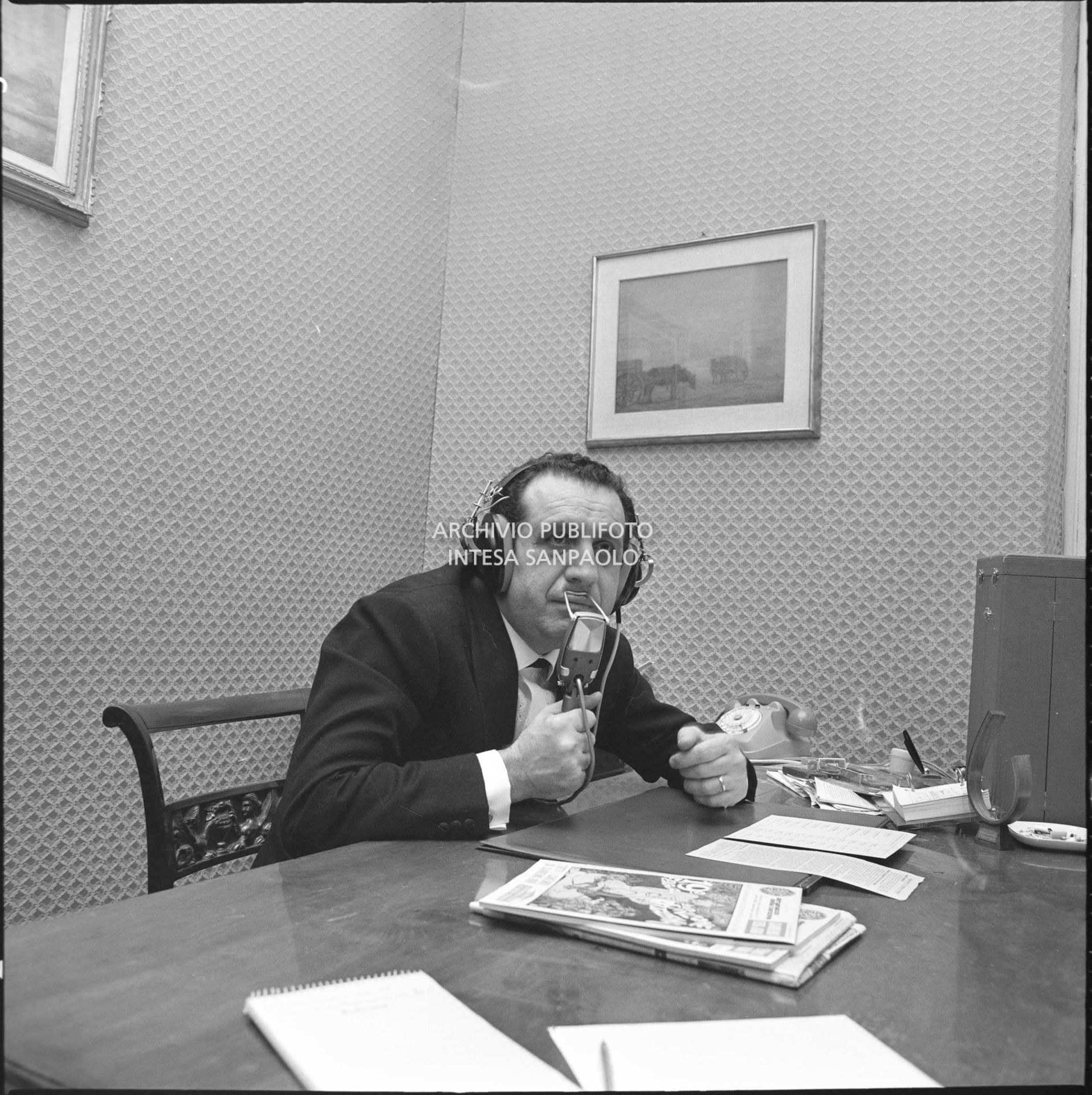 Ezio Radaelli con cuffia e microfono seduto a un tavolo in occasione del XIX Festival di Sanremo