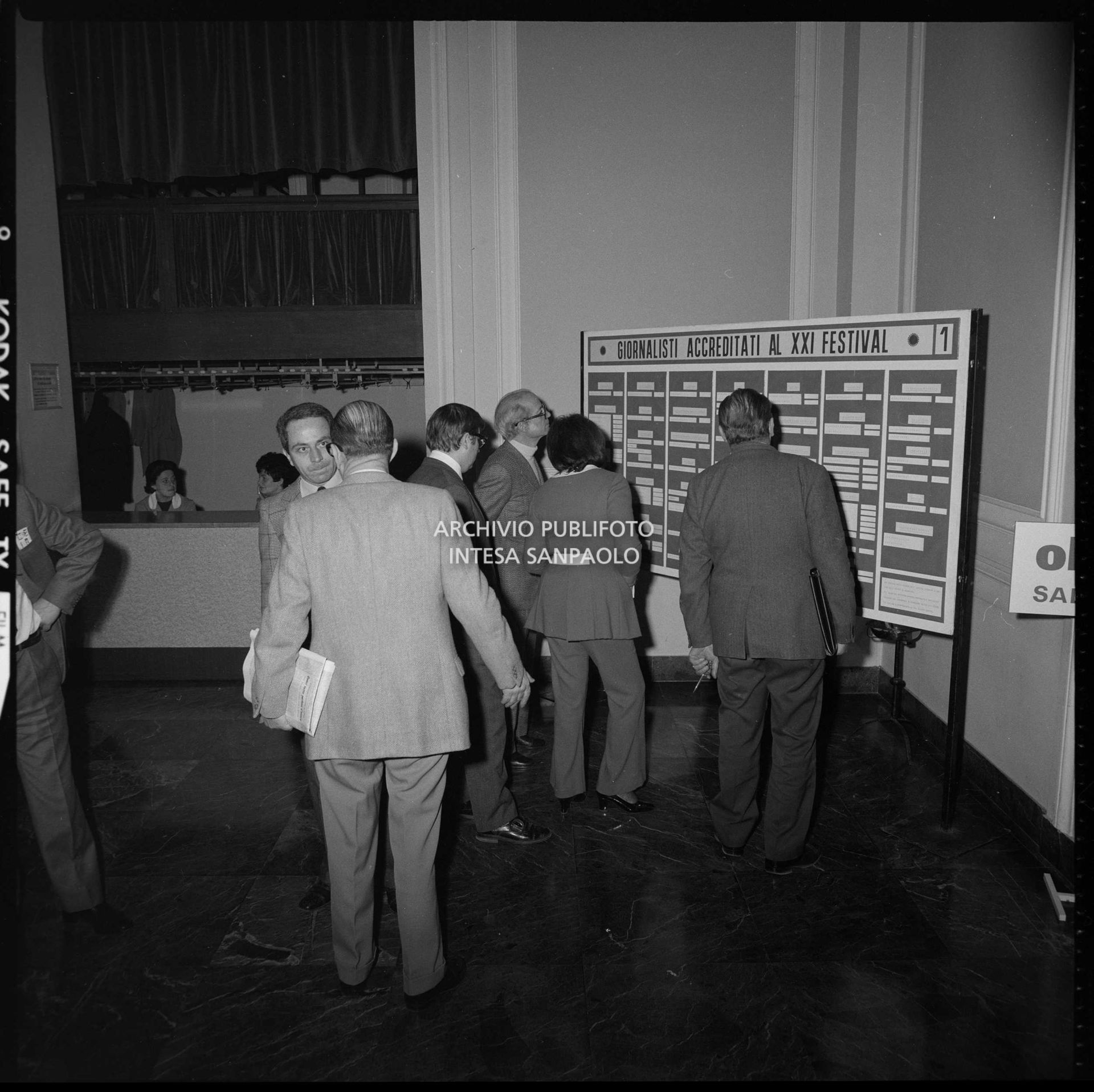 Giornalisti consultano il pannello che elenca i giornalisti accreditati al XXI Festival di Sanremo