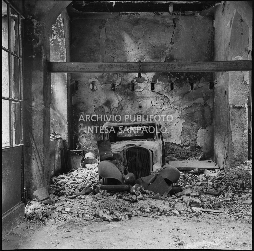 Una Fiat Balilla 508 distrutta dalle macerie dei bombardamenti che hanno sventrato l'edificio, in corso Garibaldi a Milano, sede dell'impresa Baruffaldi & Cantini che vendeva articoli casalinghi, di ferramenta e cucine economiche