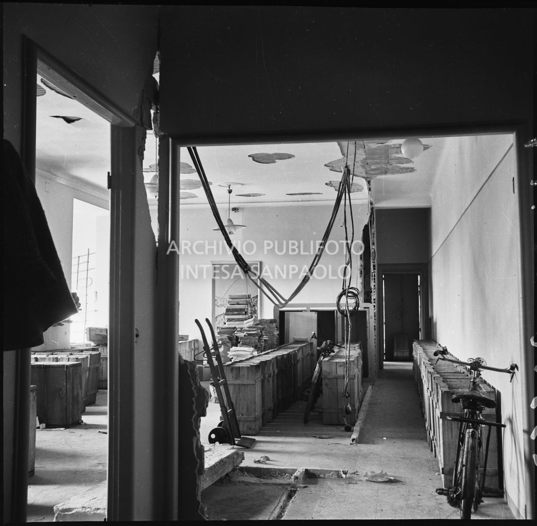 Danni agli interni della palazzina di via Ettore Bellani, sede della ditta Butera Merini & C., provocati dai bombardamenti: locale con casse di legno, biciclette, carrello