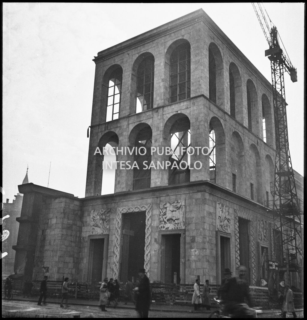Palazzo dell'Arengario danneggiato dai bombardamenti: vista dell'edificio di sinistra ripreso da piazza del Duomo; sulla destra è visibile una gru