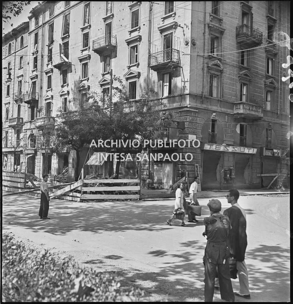 Edificio in via Vittorio Veneto angolo via Lecco, danneggiato dai bombardamenti; visibili alcuni passanti