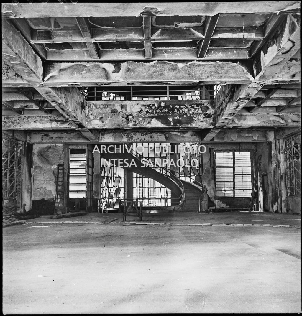 Interno del palazzo della Reale Mutua Assicurazioni di piazza Diaz danneggiato dai bombardamenti; è visibile una scalinata al centro del salone