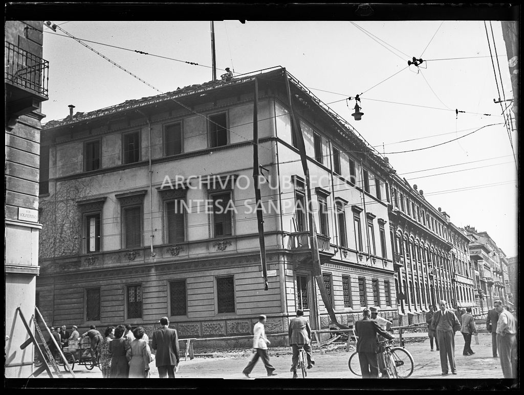 Incrocio tra via della Moscova e via Solferino: la sede del Corriere della sera danneggiata dai bombardamenti e passanti per strada
