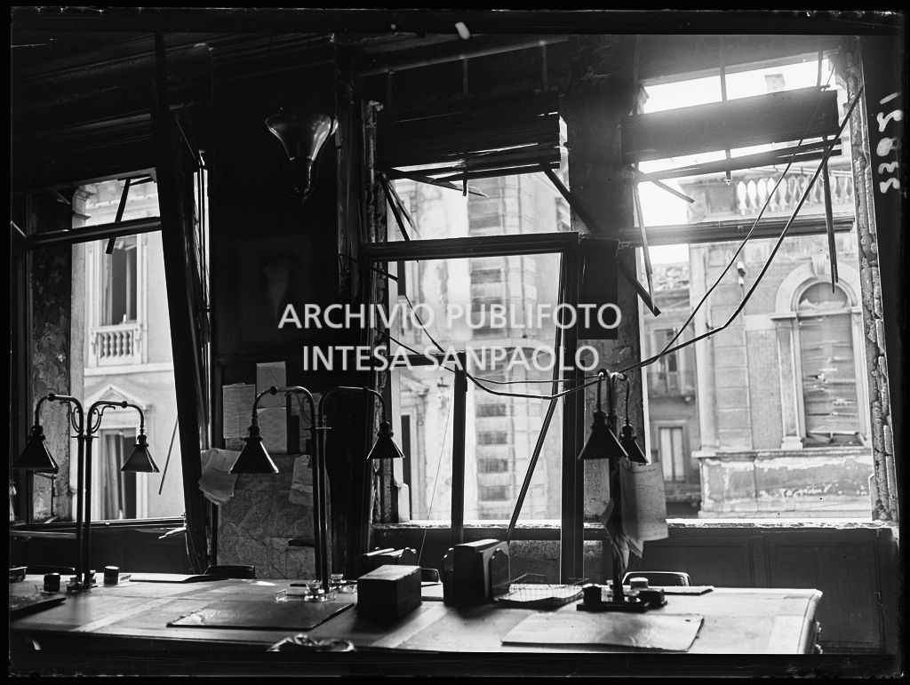 Particolare dell'interno di un ufficio del Corriere della Sera; sono visibili i danni subiti alle finestre a causa dei bombardamenti