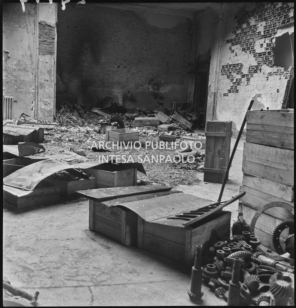 Casse di legno con materiali di lavoro tra le macerie all'interno della Società Anonima Casalegno colpita dai bombardamenti
