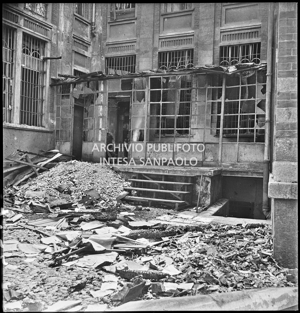 Casse in legno con materiali di lavoro tra le macerie all'interno della Società Anonima Casalegno colpita dai bombardamenti
