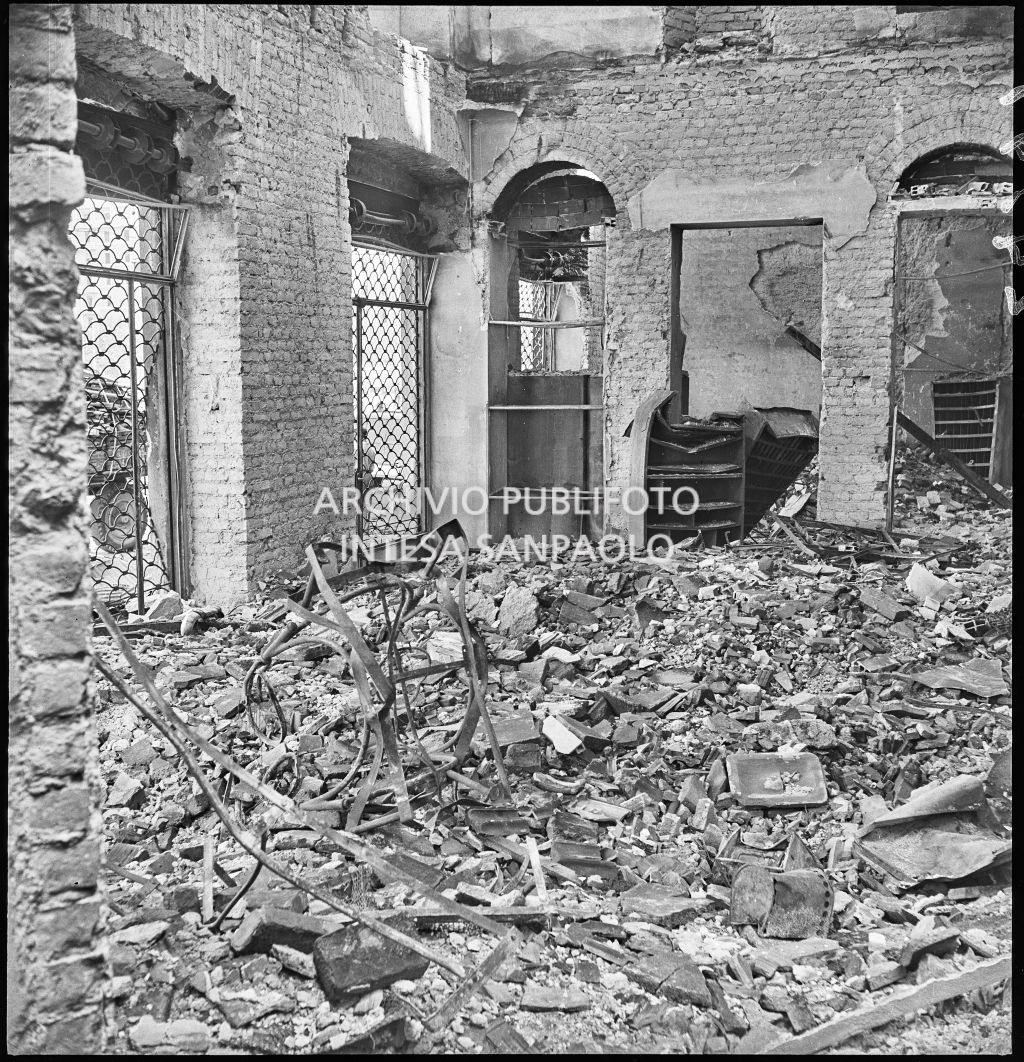 Interno della sede della Società Anonima L'Autoaccessorio, in piazza Duca d'Aosta, a Milano, distrutta dai bombardamenti e ingombra di macerie. Sulla sinistra le saracinesche che affacciano sulla piazza