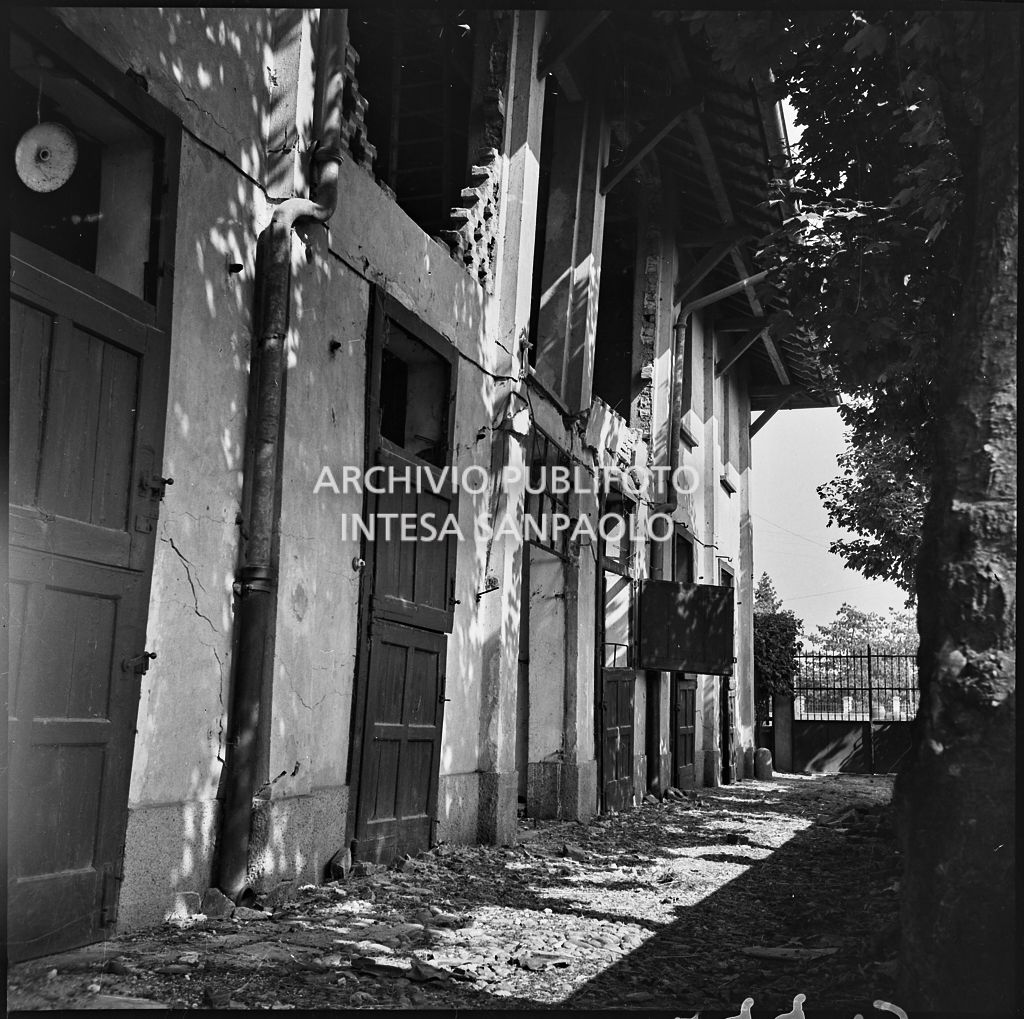 Ingresso della stalle della scuderia per cavalli da corsa Miliano, in via Pegaso a Milano, gravemente danneggiate dai bombardamenti