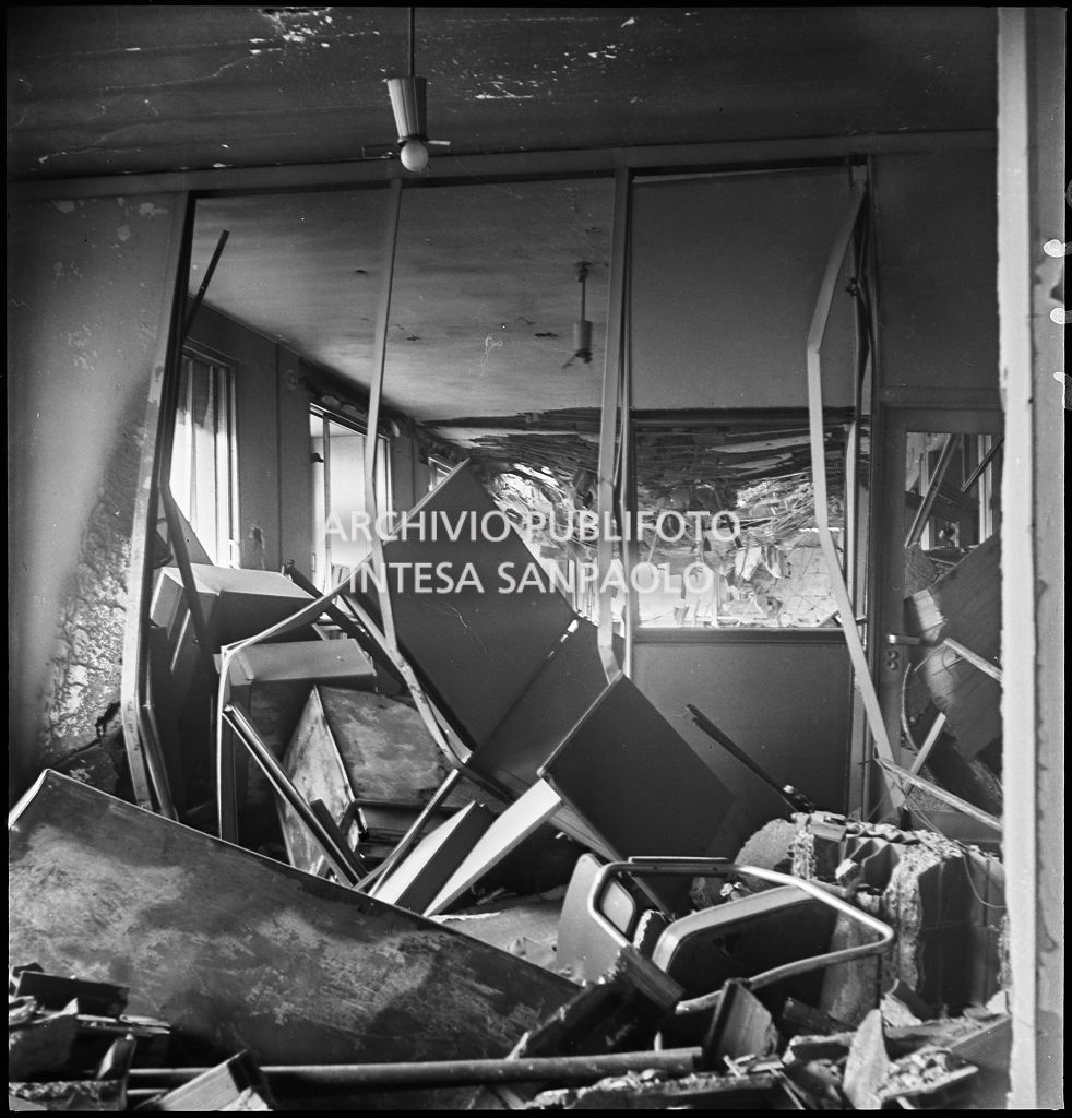 Interno di uno dei piani superiori di Palazzo Montecatini, in via della Moscova a Milano, sventrato dai bombardamenti e ingombro di macerie e arredi