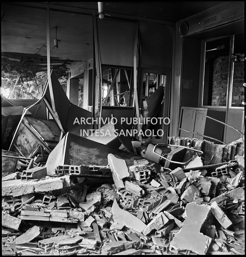 Interno di uno dei piani superiori di Palazzo Montecatini, in via della Moscova a Milano, sventrato dai bombardamenti e ingombro di macerie e arredi