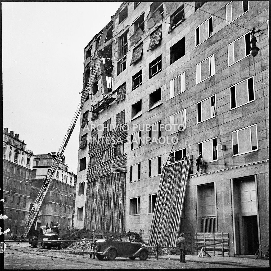 Operazioni di messa in sicurezza, anche con l'aiuto di un'autoscala, di Palazzo Montecatini, in via della Moscova a Milano, gravemente danneggiato dai bombardamenti; i piani superiori sono sventrati e un pilastro è pericolante