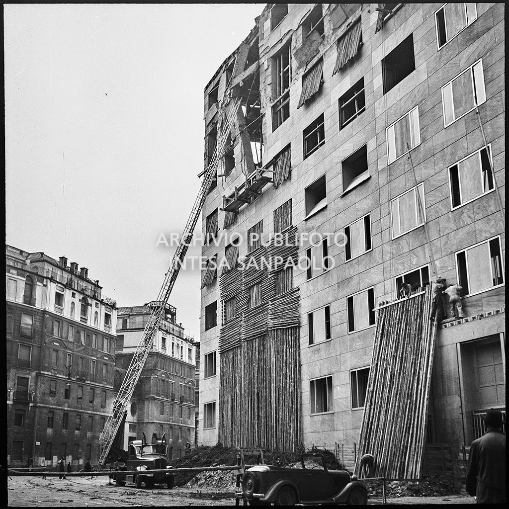 Operazioni di messa in sicurezza, anche con l'aiuto di un'autoscala, di Palazzo Montecatini, in via della Moscova a Milano, gravemente danneggiato dai bombardamenti; i piani superiori sono sventrati e un pilastro è pericolante