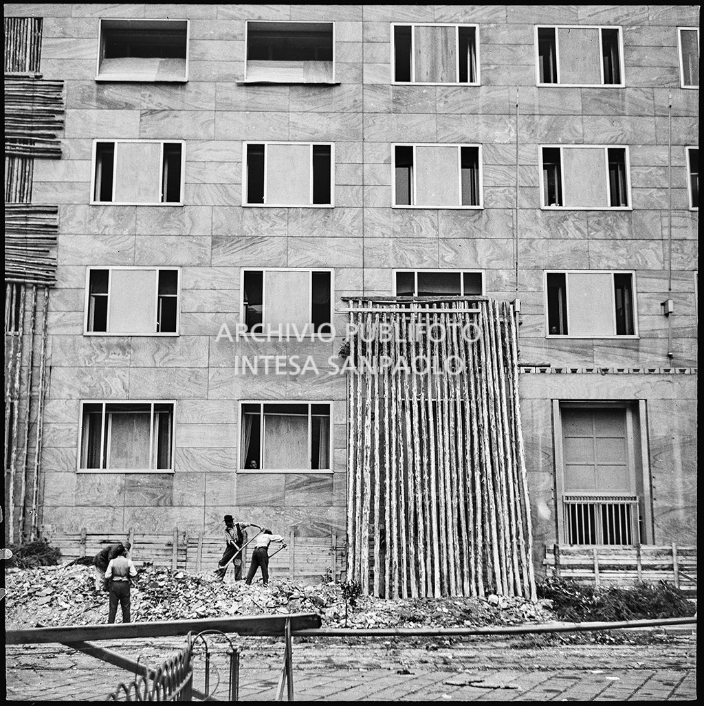 Sgombero delle macerie dei bombardamenti davanti a Palazzo Montecatini, in via della Moscova a Milano, gravemente danneggiato dagli attacchi aerei, e messo parzialmente in sicurezza