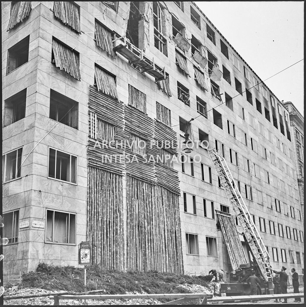 Operazioni di messa in sicurezza, anche con l'aiuto di un'autoscala, di Palazzo Montecatini, in via della Moscova a Milano, gravemente danneggiato dai bombardamenti