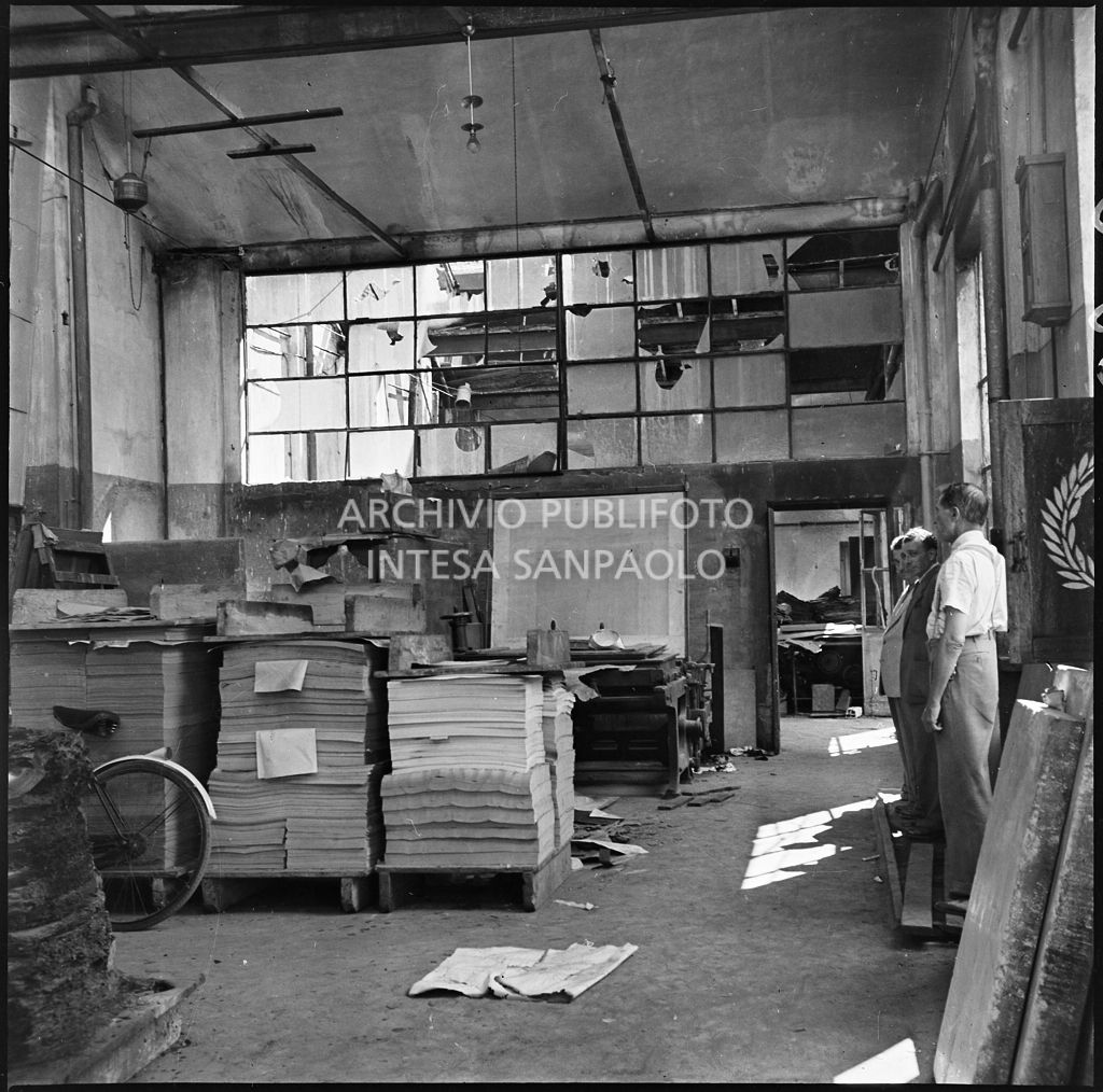 Interno dello stabilimento tipo-cromo-litografico della Società Anonima Parini Vanoni & C., in via Bezzecca a Milano, gravemente danneggiato dai bombardamenti; sulla destra tre uomini