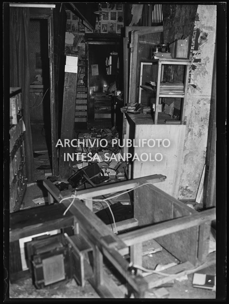 Interno dell'archivio dell'agenzia Publifoto in via Solferino 36, a Milano, danneggiato dai bombardamenti: a terra mobili e scatole con i negativi