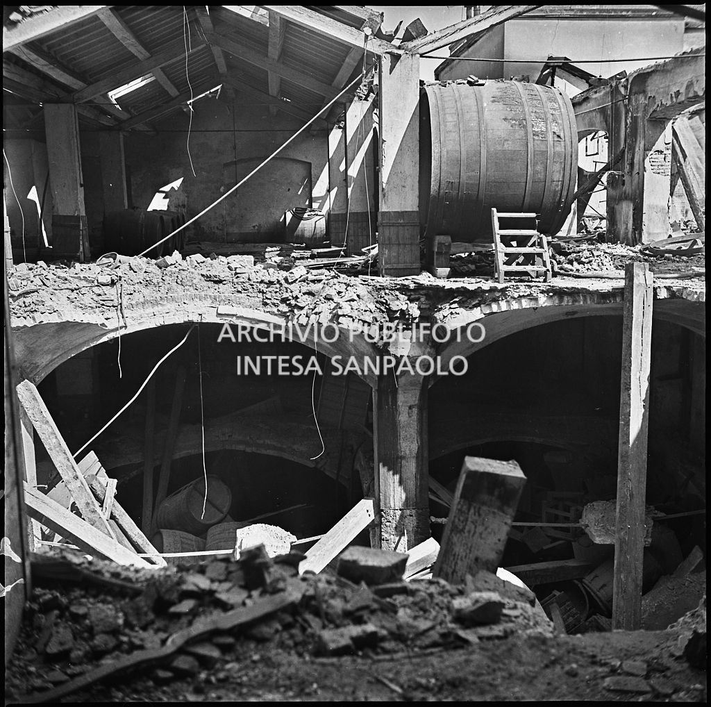 Interno dello stabilimento dell'impresa di vini e liquori Luigi Renzini, in Bastioni di Porta Genova (oggi viale Gabriele D'Annunzio) a Milano, sventrato dai bombardamenti. Al primo piano una botte per il vino
