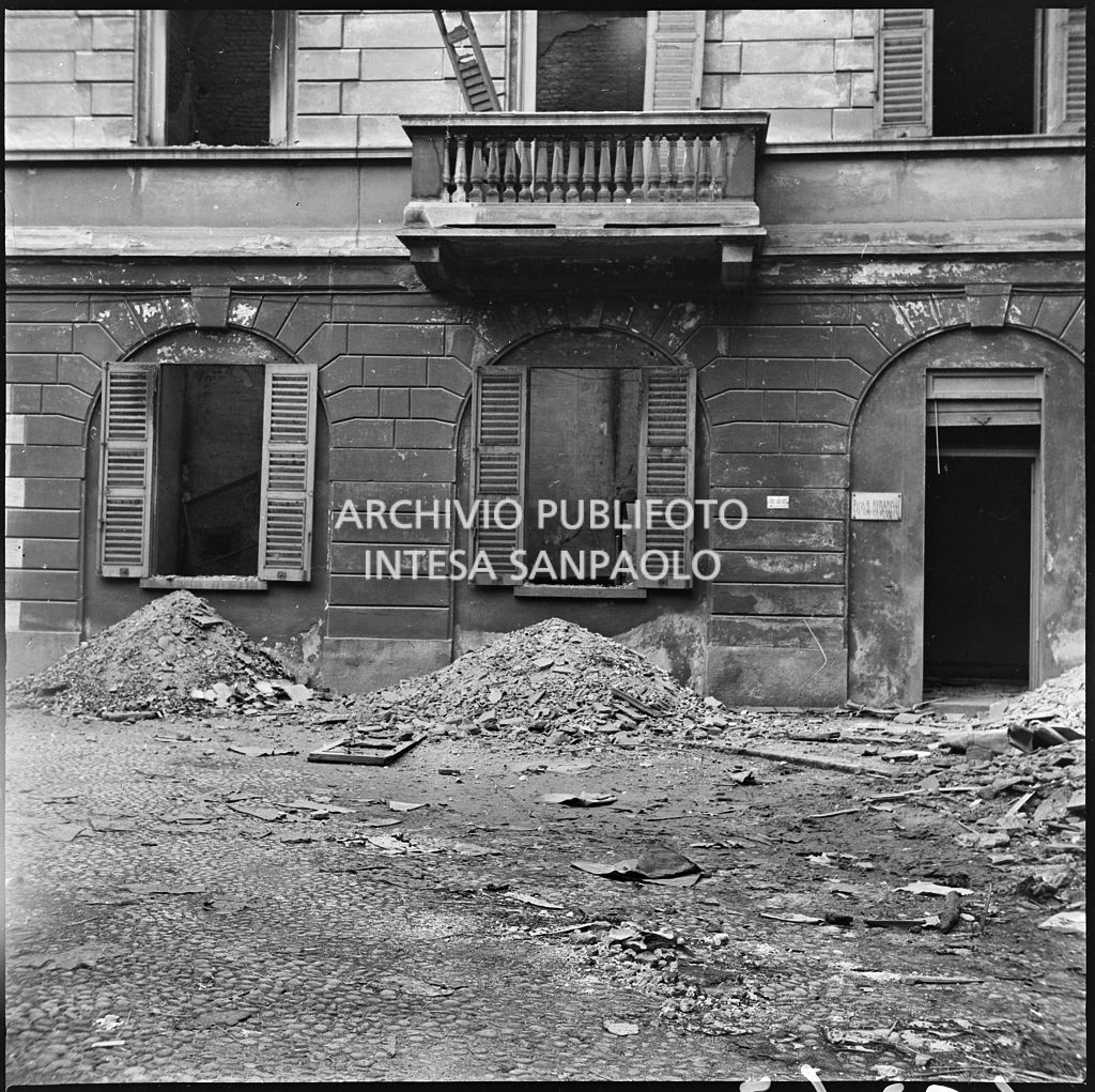 Edificio che ospitava la ditta R. Romanelli, a Milano, che produceva copertoni e tendoni impermeabili, gravemente danneggiato dai bombardamenti; la strada è ingombra di macerie