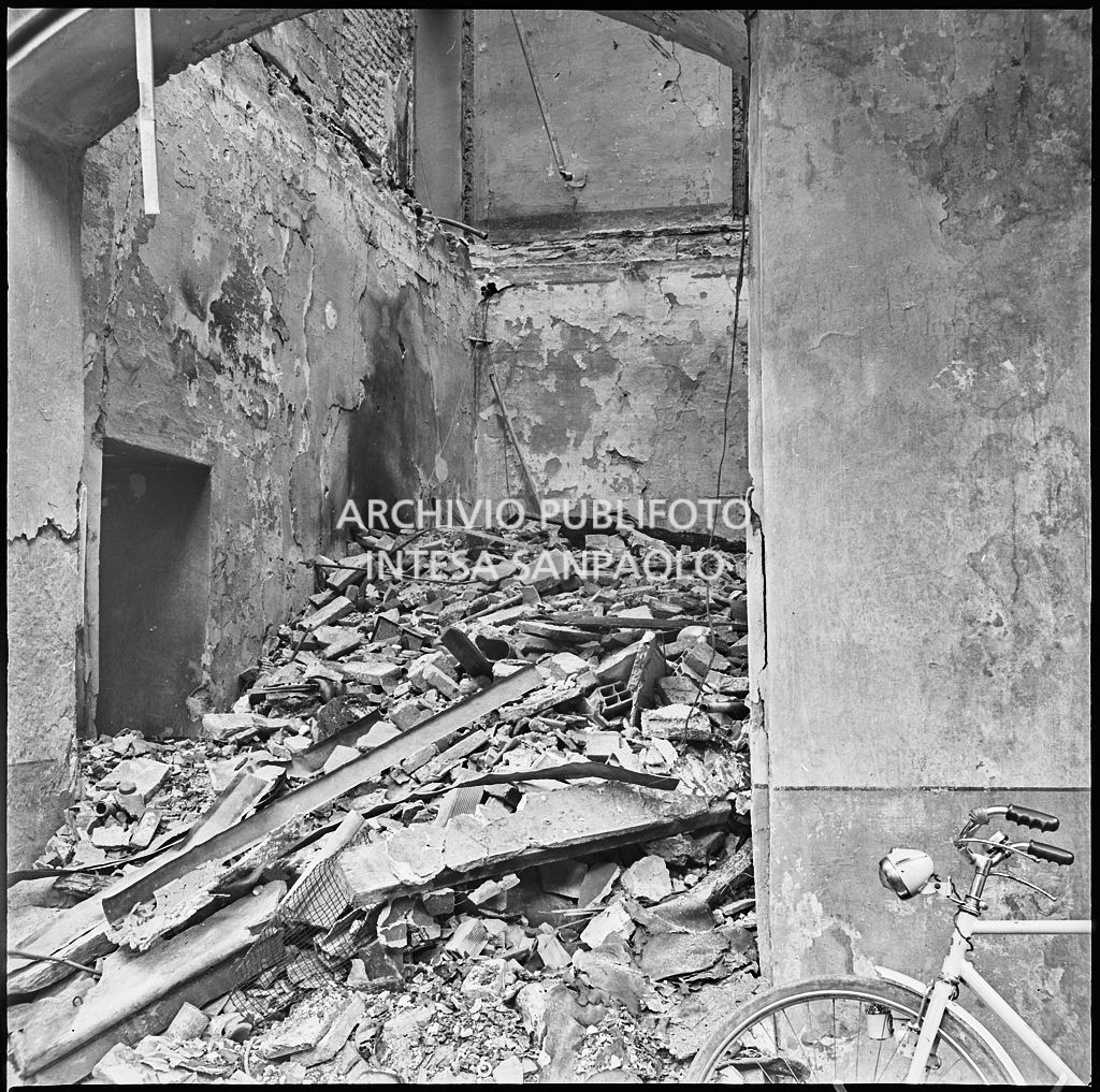 Macerie all'interno della ditta R. Romanelli, a Milano, che produceva copertoni e tendoni impermeabili, gravemente danneggiata dai bombardamenti. Sulla destra si intravede una bicicletta