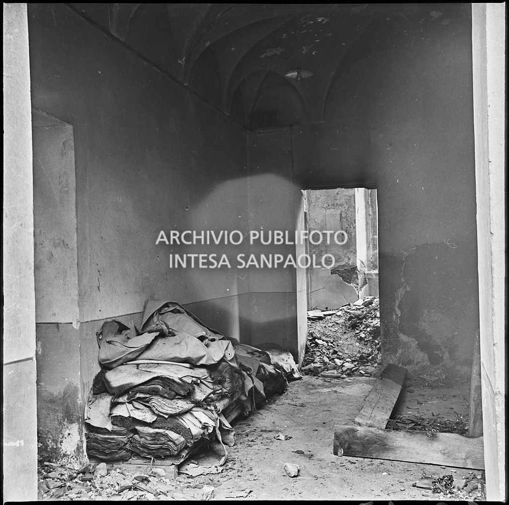 Macerie e materiale, probabilmente, di produzione all'interno della ditta R. Romanelli, a Milano, che produceva copertoni e tendoni impermeabili, gravemente danneggiata dai bombardamenti